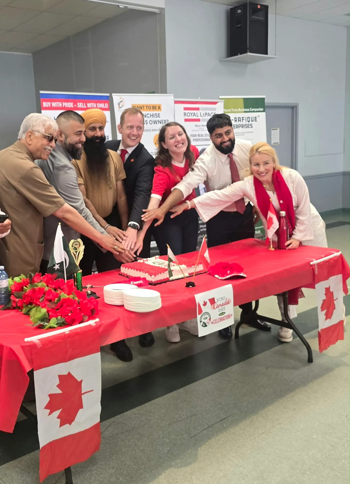Guests cutting a cake at PCBO’s Canada Day celebration.